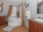 The master bathroom has a large tub and multiple sinks 